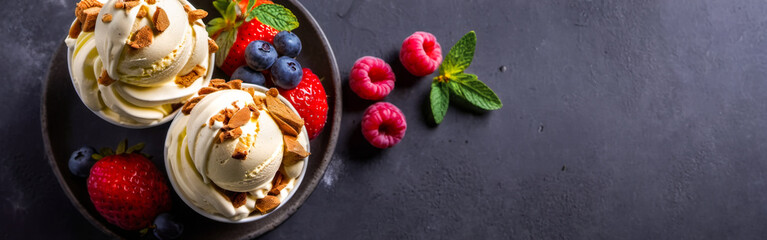 creamy ice cream servings, surrounded by strawberries, blackberries, and peach slices, presented on dark backdrop with copy space. top view