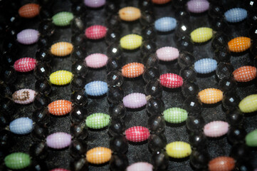 colorful mote berry beads attached to a women's bag