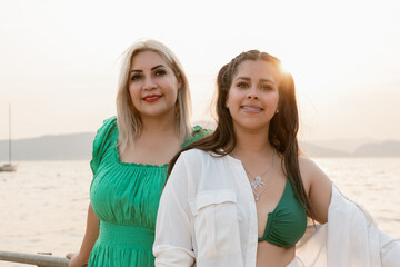 Two Women Smiling by the Lake at summer Sunset