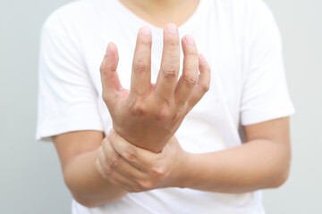 Closeup of male arms holding his painful wrist caused by prolonged work office syndrome. rheumatoid...