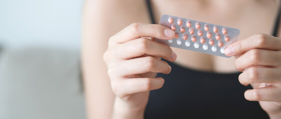 Woman hands opening birth control pills in hand. Eating Contraceptive Pill.