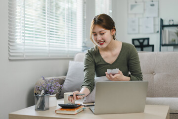 Happy asian young businesswoman calculate tax,counting paying domestic bills, e-banking,...