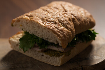Ciabatta sandwich with ham and pesto closeup