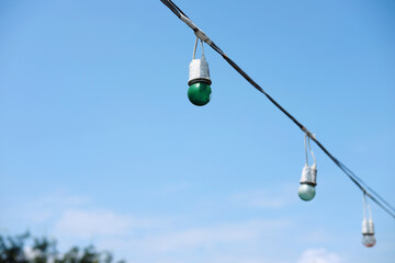 Equipped and electrical with light bulbs is hanging in the wind and sunlight on blue sky