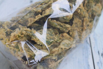 Spinach chips in plastic on the table

