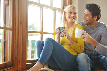 Happy couple, relax and drinking coffee by home window for morning breakfast or caffeine, bonding...