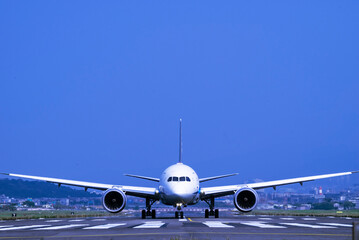 Naklejka premium A white airplane positioned on a runway, ready for takeoff. 