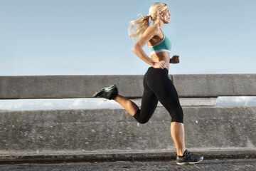 Fitness, challenge and woman on bridge for running with race, marathon or endurance training. Sports, health and female athlete runner with cardio workout for speed by highway for outdoor exercise.