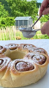 Puderzucker auf Zimtschnecken streuen