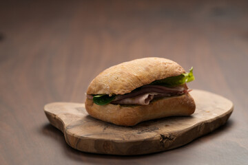 Ciabatta sandwich with ham and pesto closeup