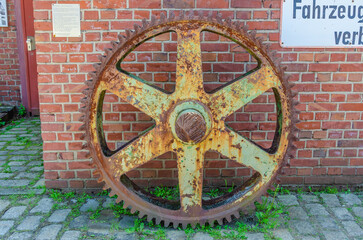 Rusty wheel on brick wall
