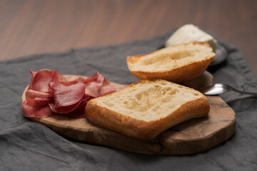 Ingredients for sandwich with bresaola, pesto and balsamic on olive board