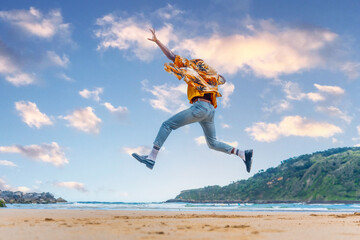 Rear view of an african man jumping on a sandy beach
