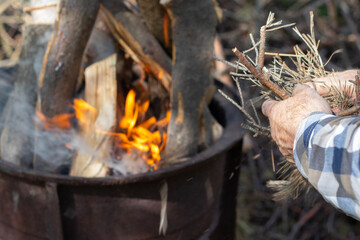 Man lights a fire in the fireplace
