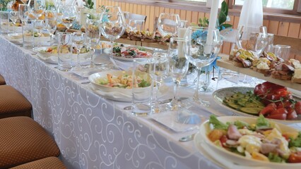 Beautiful delicious food and snacks on the festive table in the restaurant. Business lunch. A beautiful festive table covered with a variety of food. Food and drinks on the festive table.