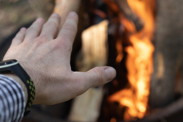 A man warming his hand by fire