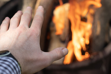 A man warming his hand by fire