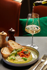 Pouring wine for gourmet hummus with shrimp and greens