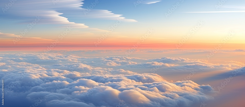 Poster cloud formations during sunrise shaped by the high altitude jet stream creating an elongated effect 