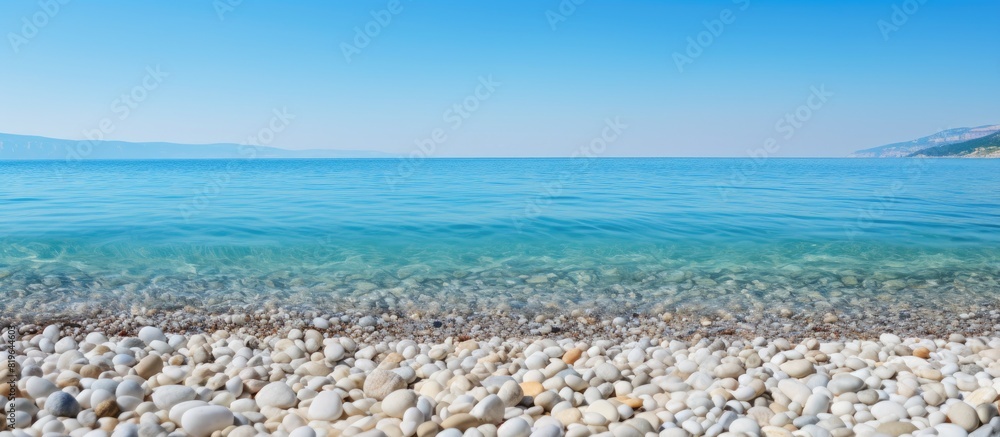 Sticker Pebble beach with the sea s clear water in the background perfect for a copy space image