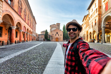 tourists taking selfie in fascinating medieval square of Bologna, one of the wonders of Italy © xamnex