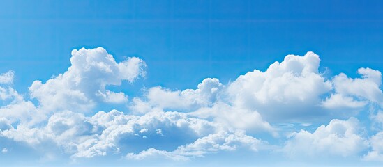 Clear sky with hints of fluffy white clouds on a serene blue background with copy space image available