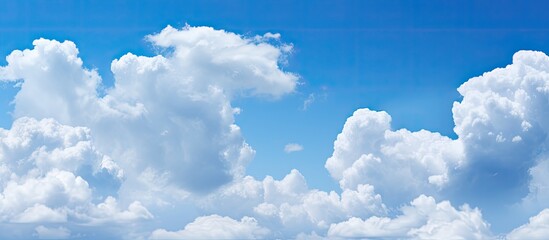 Clouds drifting across a peaceful blue sky providing an ideal copy space image