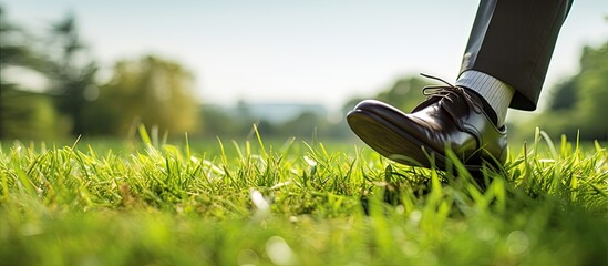 A businessman barefoot in park finding relief from stress as black shoes sit on grass beside him copyspace image
