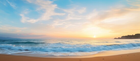 Fototapeta premium Scenic beach view at dusk with a beautiful sunset and clear blue sky in the background perfect for a copy space image