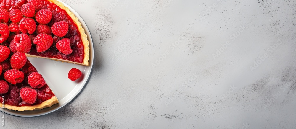 Poster slice of tart with fresh and jellied raspberries on a light concrete background in a top down view w