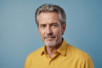 Obraz premium Portrait of charming mature man true boss feel content emotions wear yellow shirt isolated over blue color background