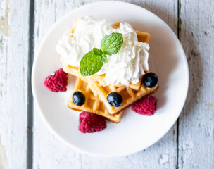 
Belgian Waffles with cream and fruit. on a wooden background. dessert
