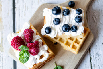 
Belgian Waffles with cream and fruit. on a wooden background. dessert