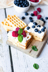 
Belgian Waffles with cream and fruit. on a wooden background. dessert