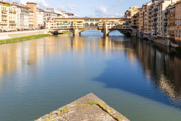 Florence, Italy - April 10, 2024: View of the Vecchio Bridge in Florence with tourists crowding its surroundings in Florence, Italy