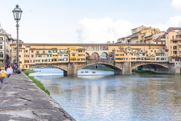 Florence, Italy - April 10, 2024: View of the Vecchio Bridge in Florence with tourists crowding its surroundings in Florence, Italy
