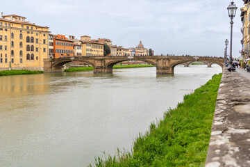 Florence, Italy - April 10, 2024: View of the Santa Trinita Bridge in Florence with tourists crowding its surroundings in Florence, Italy