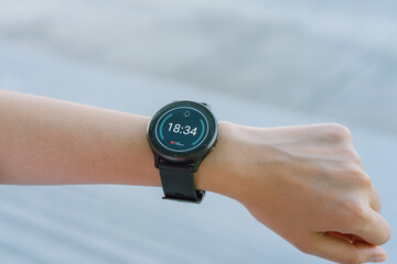 Close up of hand touching smartwatch with heart rate checking app on the screen.