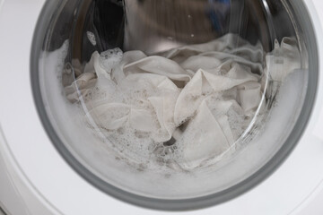 Close-up laundry running washing machine at home, amid a washing cycle, home electronics concept