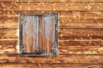 Closed wooden window with copyspace to the right on wooden wall