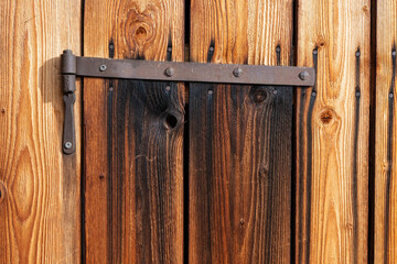 Closeup brown wooden door texture with rusty iron hinge