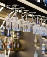 Empty Glasses hanging over a bar rack