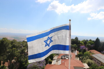 The Israeli flag flutters in the wind over the Jezreel Valley