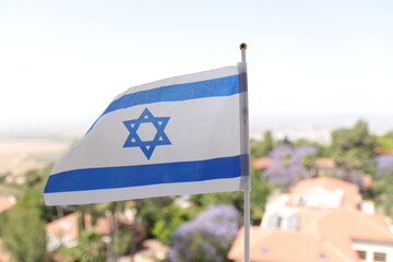 The Israeli flag flutters in the wind over the Jezreel Valley