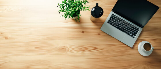 Top view of a laptop, coffee mug, and a plant on a wooden desk, ideal for a workspace mockup...