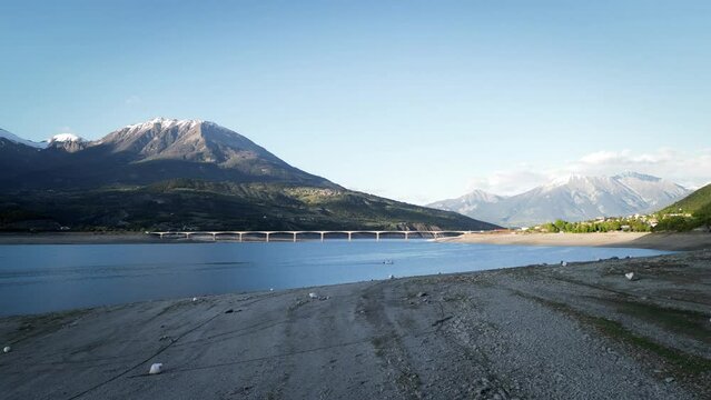 Video shooting over Lake Serre Pon&ccedil;on in the Alps in France, a large bridge that joins the two shores on the most beautiful lake in France tourist place, 4K drone