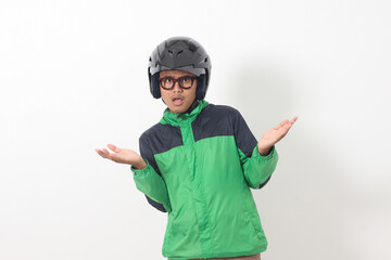 Portrait of tired Asian online taxi driver wearing green jacket and helmet doing weird funny pose. Isolated image on white background