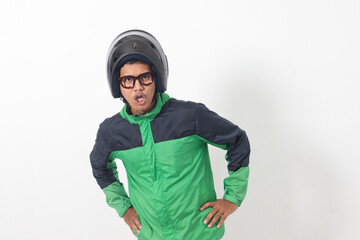 Portrait of tired Asian online taxi driver wearing green jacket and helmet doing weird funny pose. Isolated image on white background