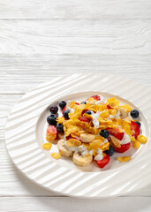 fresh berries, banana with corn flakes and yogurt