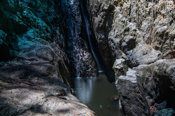A beautiful waterfall flows down the mountain. Waterfall in the tropical jungle. Colorful landscape. Waterfall in the shade.